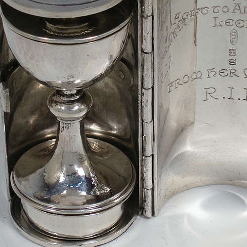 A lovely Arts and Crafts style Sterling Silver travelling communion set with hand-hammered decoration, consisting of a chalice with pull-off lid and gold-gilt interior, the lid also acting as a paten, a pyx box with hinged lid and gold-gilt interior, all fitted into an original silver cannister style hinged holder with a push-button latch and an applied Christogram on top. Made by Greenwood and Watts of London in 1927. The dimensions of this fine hand-made silver travelling communion set are length of cannister 8.5 cms (3.25 inches), height of chalice with lid 6.5 cms (2.5 inches), diameter of pyx box 3.5 cms (1.3 inches), with a total weight of approx. 212g (6.8 troy ounces). Please note that this item has an In Memorium inscription engraved on the inside of the cannister.