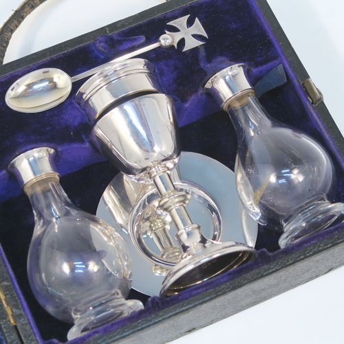 A large and complete Antique Sterling Silver six-piece travelling communion set consisting of chalice, paten, water, and wine bottles, a wafer pyx box, and an anointing spoon. The chalice having a plain round body with tapering sides, a gold-gilt interior, and sitting on a round pedestal foot. The paten and pyx box having plain round bodies. The wine and water bottles having plain round screw-off lids, cork seals, and hand-cut crystal bodies. All sitting in their original dark blue satin and velvet-lined presentation box with secure catches and carrying handles. All made by Blut and Wray of London in 1915. The dimensions of this fine hand-made antique silver travelling communion set are height of chalice 9 cms (3.5 inches), diameter of paten 8 cms (3.25 inches), and with a total weight of approx. 150g (4.8 troy ounces).