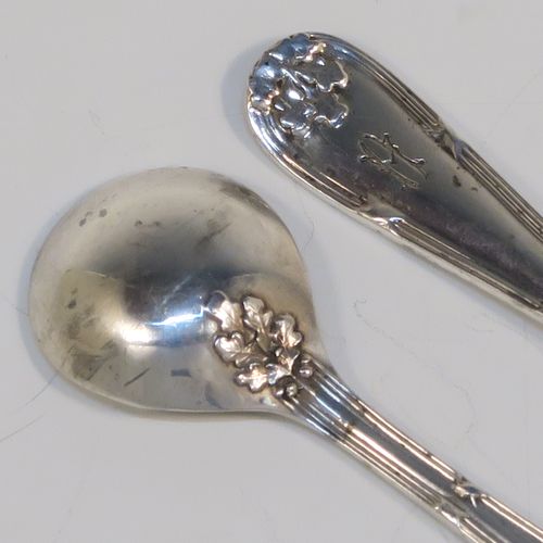 A very pretty pair of Sterling Silver salt spoons, in a double-struck Ribbon and Reed and Oak-Leaf pattern. These beautiful silver condiment spoons were made by Walker and Hall of Sheffield in 1933. The dimensions of these fine hand-made silver spoons are length 8.5 cms (3.3 inches), and they weigh a total of approx. 21g (0.7 troy ounces). Please note that they have a design registration number engraved on the back.