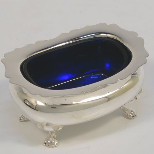 A handsome and large Antique Edwardian Silver Plated six-piece condiment service in a Chippendale style, consisting of two mustard pots with hinged lids and blue-glass liners, two salt cellars with blue-glass liners, two pepper pots with pull-off lids, all with bellied bodies and sitting on four scroll feet, together with two salt spoons and two mustard spoons, and all fitted into their original cream satin and and dark blue velvet-lined presentation box. This beautiful antique silver-plated condiment service was made by Walker and Hall of Sheffield in ca. 1910. The dimensions of this fine hand-made antique condiment service are height of pepper pots 10 cms (4 inches), length of mustard pots 10 cms (4 inches), and length of salt cellars 7.5 cms (3 inches).