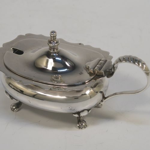 A handsome and large Antique Edwardian Silver Plated six-piece condiment service in a Chippendale style, consisting of two mustard pots with hinged lids and blue-glass liners, two salt cellars with blue-glass liners, two pepper pots with pull-off lids, all with bellied bodies and sitting on four scroll feet, together with two salt spoons and two mustard spoons, and all fitted into their original cream satin and and dark blue velvet-lined presentation box. This beautiful antique silver-plated condiment service was made by Walker and Hall of Sheffield in ca. 1910. The dimensions of this fine hand-made antique condiment service are height of pepper pots 10 cms (4 inches), length of mustard pots 10 cms (4 inches), and length of salt cellars 7.5 cms (3 inches).
