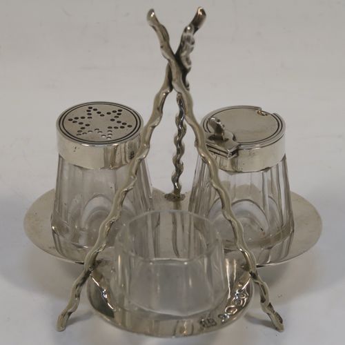 A very pretty and unusual Antique Victorian Sterling Silver Campfire style condiment set, consisting of a pepper shaker, mustard pot, and open salt with panelled cystal bodies and silver tops, all sitting in a campfire style frame with three tree branches joined together. This beautiful antique silver and crystal condiment set was made by Heath and Middleton of Birmingham in 1889. The dimensions of this fine hand-made antique silver condiment set are height 10 cms (4 inches), width 10 cms (4 inches), and it weighs approx. 70g (2.3 troy ounces).  