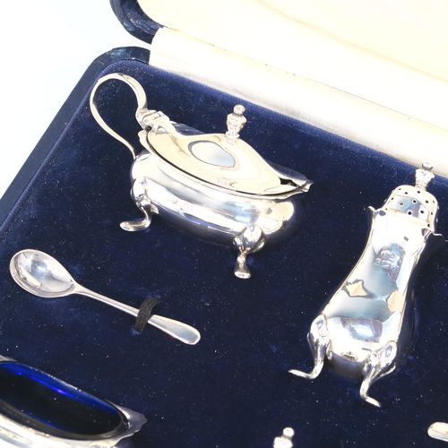 A handsome Antique Sterling Silver six-piece condiment service in the Chippendale style, consisting of two mustard pots with hinged lids and blue-glass liners, two salt cellars with blue-glass liners, two pepper pots with pull-off lids, all with bellied bodies and sitting on four scroll feet, together with two salt spoons and two mustard spoons, and all fitted into their original cream satin and and dark blue velvet-lined presentation box. This beautiful antique silver condiment service was made by Suckling Ltd., of Sheffield in 1923/4. The dimensions of this fine hand-made antique condiment service are height of pepper pots 7.5 cms (3 inches), length of mustard pots 7.5 cms (3 inches), and length of salt cellars 6 cms (2.3 inches), and with a total weight of approx. 208g (6.7 toy ounces).