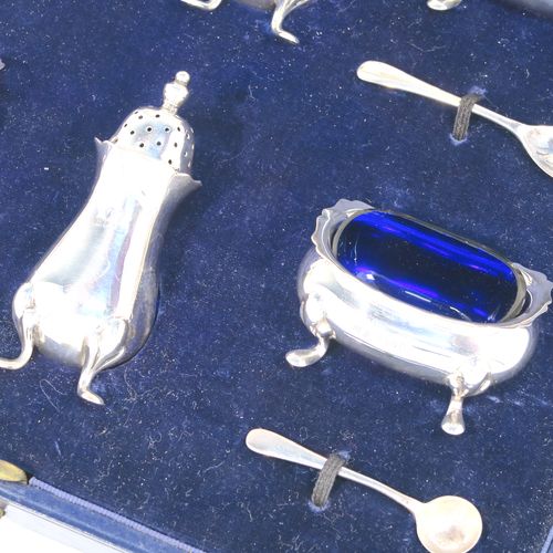 A handsome Antique Sterling Silver six-piece condiment service in the Chippendale style, consisting of two mustard pots with hinged lids and blue-glass liners, two salt cellars with blue-glass liners, two pepper pots with pull-off lids, all with bellied bodies and sitting on four scroll feet, together with two salt spoons and two mustard spoons, and all fitted into their original cream satin and and dark blue velvet-lined presentation box. This beautiful antique silver condiment service was made by Suckling Ltd., of Sheffield in 1923/4. The dimensions of this fine hand-made antique condiment service are height of pepper pots 7.5 cms (3 inches), length of mustard pots 7.5 cms (3 inches), and length of salt cellars 6 cms (2.3 inches), and with a total weight of approx. 208g (6.7 toy ounces).