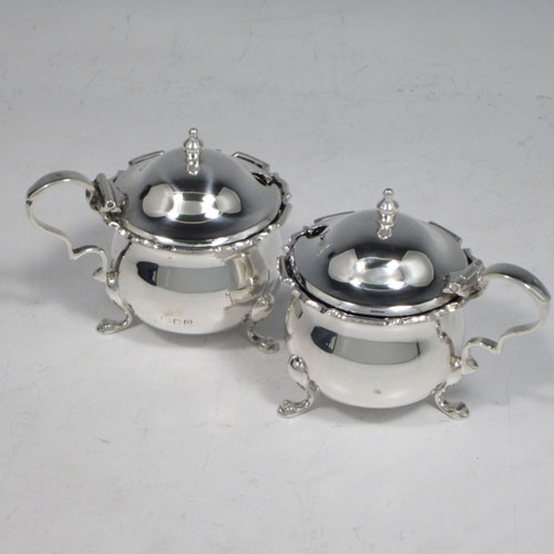 Antique sterling silver eight-piece condiment set, consisting of four open salt cellars with blue-glass liners, two mustard pots with hinged lids, and two pepper shakers, all with plain baluster round bodies, chippendale borders, and sitting on four cabriole legs, and all fitted into an original satin and velvet-lined presentation box. Made by Robert and William Sorely pf London in 1911. The dimensions of this fine hand-made silver condiment service are height of pepper pots 7 cms (2.75 inches), length of mustard pots 7 cms (2.75 inches), and with a total weight of approx. 252g (8 troy ounces). 
