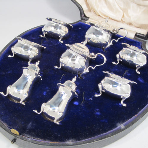 Antique sterling silver eight-piece condiment set, consisting of four open salt cellars with blue-glass liners, two mustard pots with hinged lids, and two pepper shakers, all with plain baluster round bodies, chippendale borders, and sitting on four cabriole legs, and all fitted into an original satin and velvet-lined presentation box. Made by Robert and William Sorely pf London in 1911. The dimensions of this fine hand-made silver condiment service are height of pepper pots 7 cms (2.75 inches), length of mustard pots 7 cms (2.75 inches), and with a total weight of approx. 252g (8 troy ounces). 
