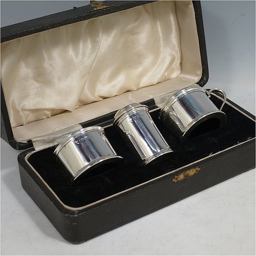 A Sterling Silver three-piece condiment set, in a very plain round Georgian style with applied reeded borders, and consisting of a pepper pot, open salt cellar, and covered mustard pot, the latter two items with original blue glass liners, and all in their original cream satin and black velvet-lined presentation box. Made by J. B Chatterley & Sons Ltd., of Birmingham in 1940. The dimensions of this fine hand-made silver condiment service are height of pepper pot 5.5 cms (2.25 inches), length of mustard pot 6.5 cms (2.5 inches), and the total weight is approx. 93g (3 troy ounces).   