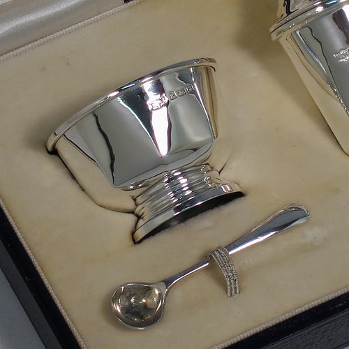 A Sterling Silver three-piece condiment set, in a panelled Art Deco style, and consisting of a pepper pot, open salt cellar, and covered mustard pot, the latter two items with original blue glass liners, and sitting on pedestal feet, the pepper pot with a pull-off lid with finial, and together with two silver condiment spoons, and all in their original cream satin & velvet-line presentation box. Made by Mappin & Webb of Birmingham in 1930 (the spoons being made in 1902). The dimensions of this fine hand-made silver condiment service are height of pepper pot 7 cms (2.75 inches), length of mustard pot 6.5 cms (2.5 inches), and the total weight is approx. 89g (2.9 troy ounces).