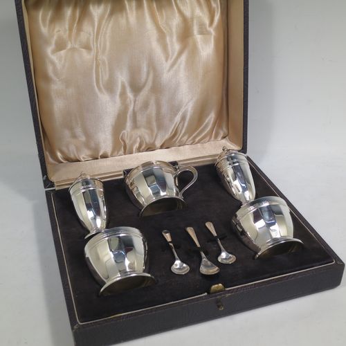 A very stylish Sterling Silver Art Deco five-piece condiment service in a plain round panelled style, consisting of a covered mustard pot with blue-glass liner, two open salts with blue-glass liners, two pepper shakers with pull-off lids, and three condiment spoons, all in their cream satin & black velvet-lined presentation box. Made by Deakin and Francis of Birmingham in 1928. The dimensions of this fine hand-made silver condiment service are height of peppers 8 cms (3.25 inches), length of mustard pot 7 cms (2.75 inches), with a total weight of approx. 281g (9 troy ounces).    