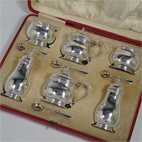 A large and heavy Sterling Silver six-piece condiment service, consisting of two mustard pots with hinged lids, gold-gilt interiors and scroll side-handles, two salt cellars with gold-gilt interiors, two pepper pots with pull-off lids, all with plain oval bellied bodies sitting on collet feet, together with their original condiment spoons, and all fitted into their original cream satin and velvet-lined red presentation box. Made by Edwards and Sons of Chester in 1918. The dimensions of this fine hand-made condiment service are height of pepper pot 11 cms (4.3 inches), length of mustard pot 9 cms (3.5 inches), and with a total weight of approx. 568g (18 troy ounces).