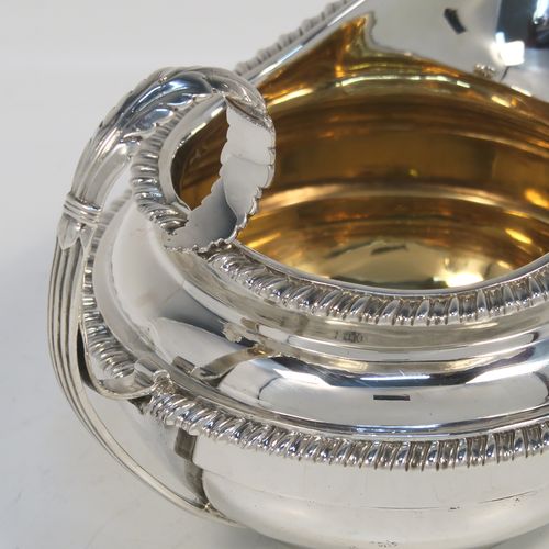 A very handsome Antique Georgian Sterling Silver large cream jug, having a plain round bellied body with applied gadroon borders, a scroll handle with floral thumb-piece, a gold-gilt interior, and all sitting on a round collet foot. This elegant silver milk or cream jug was made by the Emes and Barnard of London in 1820. The dimensions of this fine hand-made antique silver cream jug are height 10 cms (4 inches), length 14 cms (5.5 inches), and it weighs approx. 247g (8 troy ounces).