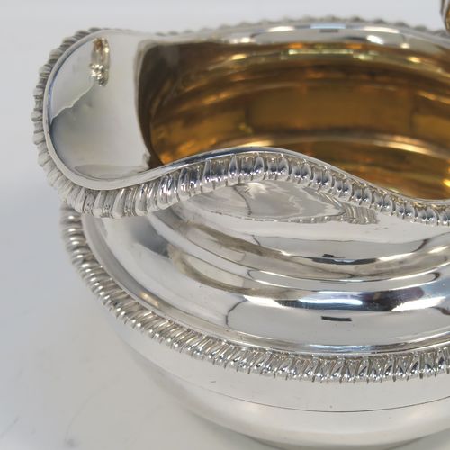 A very handsome Antique Georgian Sterling Silver large cream jug, having a plain round bellied body with applied gadroon borders, a scroll handle with floral thumb-piece, a gold-gilt interior, and all sitting on a round collet foot. This elegant silver milk or cream jug was made by the Emes and Barnard of London in 1820. The dimensions of this fine hand-made antique silver cream jug are height 10 cms (4 inches), length 14 cms (5.5 inches), and it weighs approx. 247g (8 troy ounces).