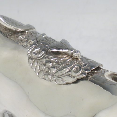 An Antique Victorian Sterling Silver Dutch Cow cream jug, in a George II Cow creamer style, having a hinged lid with hand-chased flowers and an applied model of a bee, with a handle made from from the cows looped tail, and a spout made from the cows mouth, all sitting on four hoof feet. Made in ca. 1880 with Dutch hallmarks. The dimensions of this fine hand-made silver cow creamer are length 14.5 cms (5.75 inches), height 10 cms (4 inches), and it weighs approx. 126g (4 troy ounces).