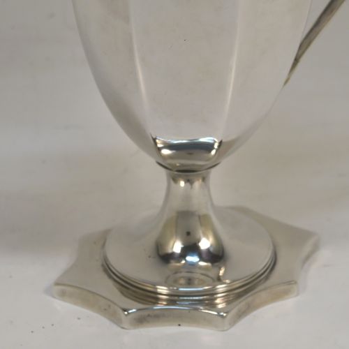 A very handsome Antique Georgian Sterling Silver cream jug, having a plain panelled octagonal body with tapering sides in a Helmet style, a reeded scroll handle and applied top border, and sitting on a pedestal foot with an octagonal shaped base. This beautiful silver cream jug was made by Henry Chawner of London in 1787. The dimensions of this fine hand-made antique silver cream jug are length 13 cms (5 inches), height 14.5 cms (5.75 inches), and it weighs approx. 153g (4.9 troy ounces). Please note that this item is crested.