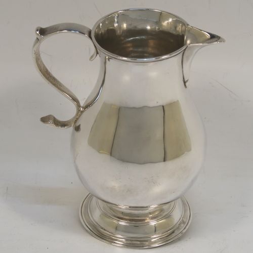 A very handsome Antique Georgian Sterling Silver cream jug, in the sparrow-beak style, having a plain round bellied body, scroll handle, and sitting on a round pedestal foot. This beautiful silver cream jug was made by Henry Brind of London in 1746. The dimensions of this fine hand-made antique silver cream jug are height 10 cms (4 inches), length 8 cms (3 inches), and it weighs approx. 81g (2.6 troy ounces).   