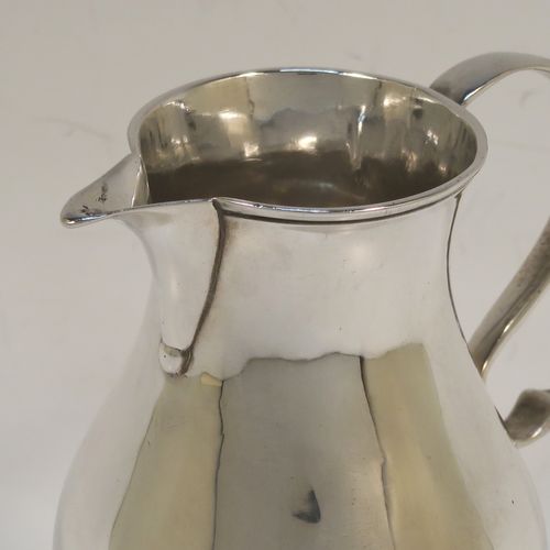 A very handsome Antique Georgian Sterling Silver cream jug, in the sparrow-beak style, having a plain round bellied body, scroll handle, and sitting on a round pedestal foot. This beautiful silver cream jug was made by Henry Brind of London in 1746. The dimensions of this fine hand-made antique silver cream jug are height 10 cms (4 inches), length 8 cms (3 inches), and it weighs approx. 81g (2.6 troy ounces).