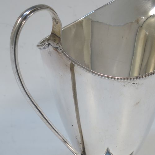 A very elegant Antique Georgian Sterling Silver cream jug, having a round body with tapering sides in a Helmet style, an applied bead-edged border, a reeded scroll handle, and sitting on a pedestal foot with a square base. Made in London in 1790. The dimensions of this fine hand-made antique silver cream jug are length 12 cms (4.75 inches), height 13 cms (5 inches), and it weighs approx. 117g (3.8 troy ounces). Please note that this item is crested.