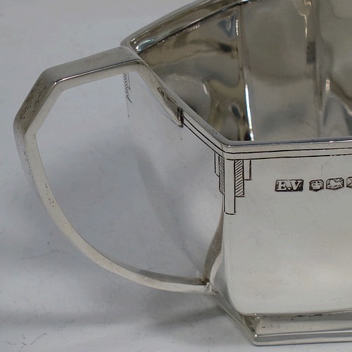 A very handsome Art Deco Sterling Silver cream jug, having a plain panelled rectangular body, a sparrow-beak spout, a cast angular handle, an applied top border with hand-engraved reeding and Deco style decals, and sitting on a collet foot. Made by Emile Viner of Sheffield in 1940. The dimensions of this fine hand-made Art Deco silver cream jug are height 7 cms (2.75 inches), length 15.5 cms (6 inches), width 7.5 cms (3 inches), and it weighs approx. 198g (6.4 troy ounces).
