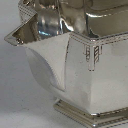 A very handsome Art Deco Sterling Silver cream jug, having a plain panelled rectangular body, a sparrow-beak spout, a cast angular handle, an applied top border with hand-engraved reeding and Deco style decals, and sitting on a collet foot. Made by Emile Viner of Sheffield in 1940. The dimensions of this fine hand-made Art Deco silver cream jug are height 7 cms (2.75 inches), length 15.5 cms (6 inches), width 7.5 cms (3 inches), and it weighs approx. 198g (6.4 troy ounces).