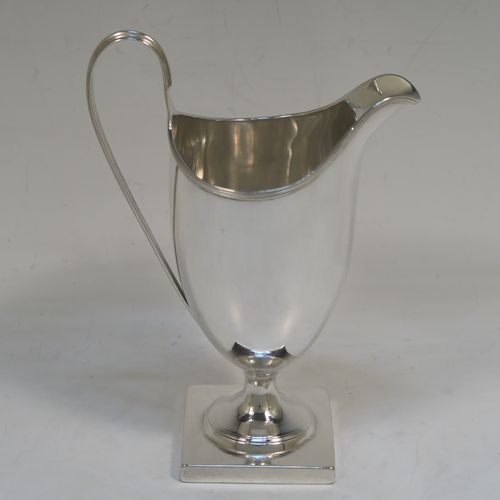 A handsome Antique Georgian Sterling Silver milk or cream jug, having a round body with tapering sides in a Helmet style, with an applied reeded border, a reeded looped handle, and sitting on a pedestal foot with a square base. This elegant antique silver cream or milk jug was made by Stephen Adams I of London in 1794. The dimensions of this fine hand-made antique silver cream jug are length 11 cms (4.3 inches), height 15.5 cms (6 inches), and it weighs approx. 112g (3.6 troy ounces).  
