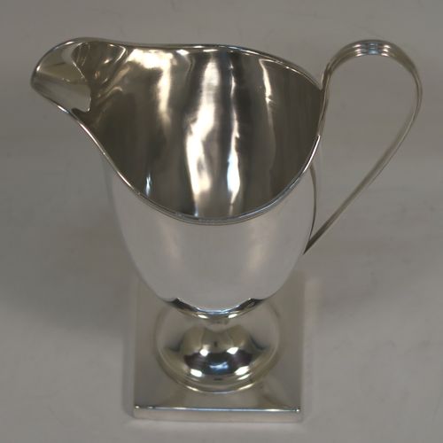 A handsome Antique Georgian Sterling Silver milk or cream jug, having a round body with tapering sides in a Helmet style, with an applied reeded border, a reeded looped handle, and sitting on a pedestal foot with a square base. This elegant antique silver cream or milk jug was made by Stephen Adams I of London in 1794. The dimensions of this fine hand-made antique silver cream jug are length 11 cms (4.3 inches), height 15.5 cms (6 inches), and it weighs approx. 112g (3.6 troy ounces).