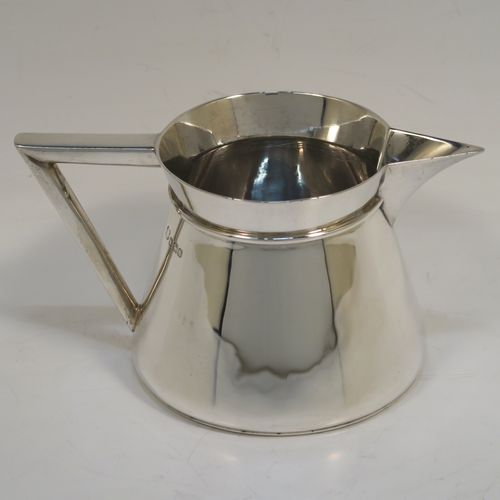 An unusual Arts and Crafts style Antique Sterling Silver cream jug, having a plain round body with tapering sides, an angular side-handle, a sparrow-beak spout, and sitting on a flat base. This beautiful silver cream jug was made by Pearce and Sons of Sheffield in 1913. The dimensions of this fine hand-made antique Arts and Crafts silver cream jug are height 7 cms (2.75 inches), length 13.5 cms (5.25 inches), and it weighs approx. 168g (5.4 troy ounces).  