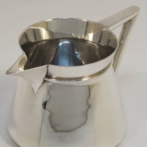 An unusual Arts and Crafts style Antique Sterling Silver cream jug, having a plain round body with tapering sides, an angular side-handle, a sparrow-beak spout, and sitting on a flat base. This beautiful silver cream jug was made by Pearce and Sons of Sheffield in 1913. The dimensions of this fine hand-made antique Arts and Crafts silver cream jug are height 7 cms (2.75 inches), length 13.5 cms (5.25 inches), and it weighs approx. 168g (5.4 troy ounces).