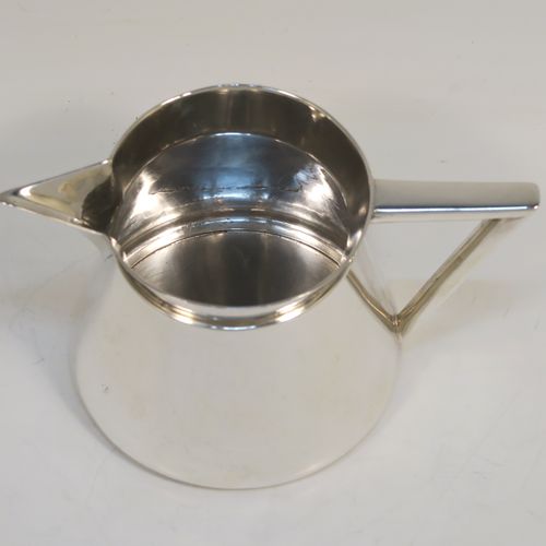 An unusual Arts and Crafts style Antique Sterling Silver cream jug, having a plain round body with tapering sides, an angular side-handle, a sparrow-beak spout, and sitting on a flat base. This beautiful silver cream jug was made by Pearce and Sons of Sheffield in 1913. The dimensions of this fine hand-made antique Arts and Crafts silver cream jug are height 7 cms (2.75 inches), length 13.5 cms (5.25 inches), and it weighs approx. 168g (5.4 troy ounces).