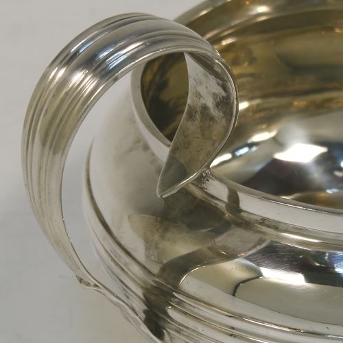 A very elegant Antique Georgian Sterling Silver milk or cream jug, having a plain round bellied body with, applied reeded decoration, a scroll side handle, and sitting on a collet foot. This handsome antique silver cream or milk jug was made by Emes and Barnard of London in 1823. The dimensions of this fine hand-made antique silver jug are height 8.5 cms (3.3 inches), length 14 cms (5.5 inches), and it weighs approx. 221g (7 troy ounces).