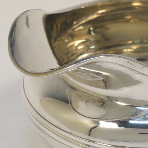 A very elegant Antique Georgian Sterling Silver milk or cream jug, having a plain round bellied body with, applied reeded decoration, a scroll side handle, and sitting on a collet foot. This handsome antique silver cream or milk jug was made by Emes and Barnard of London in 1823. The dimensions of this fine hand-made antique silver jug are height 8.5 cms (3.3 inches), length 14 cms (5.5 inches), and it weighs approx. 221g (7 troy ounces).