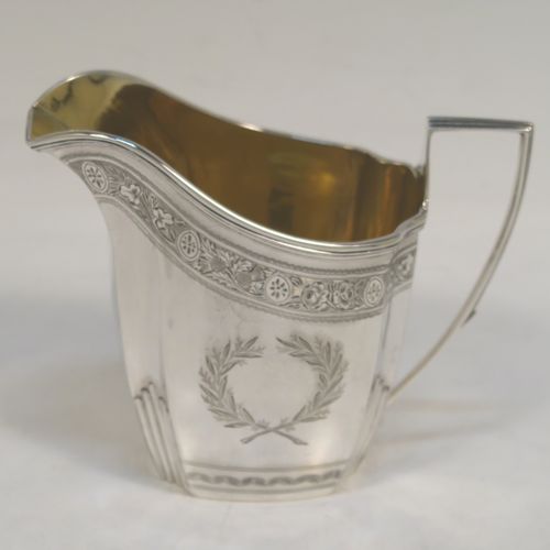 A very pretty Antique Victorian Sterling Silver milk or cream jug, having a panelled oval mainly straight-sided body, with hand-engraved bands of floral decoration, and hand-chased half-fluted corners, a gold-gilt interior, an applied reeded border, a scroll handle with flat top, and sitting on a flat base. This beautiful antique silver cream or milk jug was made by J. B. Carrington of London in 1887. The dimensions of this fine hand-made antique silver jug are height 10 cms (4 inches), length 12.5 cms (5 inches), and it weighs approx. 137g (4.4 troy ounces).  