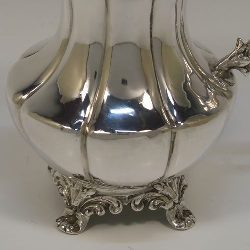 A very pretty and large Antique early Victorian Sterling Silver milk or cream jug, having a round body with hand-chased melon fluting, an applied reeded top border, a scroll handle with anthemion leaf thumb-piece, a gold-gilt interior, and all sitting on four cast foliate feet. This beautiful silver milk jug was made by Hayne and Cater of London in 1837. The dimensions of this fine hand-made antique silver cream jug are height 14 cms (4.5 inches), length 15 cms (6 inches), and it weighs approx. 237g (7.6 troy ounces).
