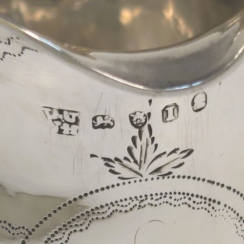 A very pretty Antique Georgian Sterling Silver cream jug, having a round bellied body with hand-engraved bands of stipple and floral work, an applied reeded border and reeded scroll handle, and all sitting on a flat base. This elegant antique silver cream jug was made by Urquart and Hart of London in 1786. The dimensions of this fine hand-made antique silver cream jug are height cms (3.75 inches), length 11 cms (4.3 inches), and it weighs approx. 78g (2.5 troy ounces).