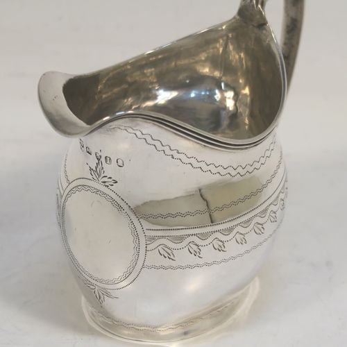 A very pretty Antique Georgian Sterling Silver cream jug, having a round bellied body with hand-engraved bands of stipple and floral work, an applied reeded border and reeded scroll handle, and all sitting on a flat base. This elegant antique silver cream jug was made by Urquart and Hart of London in 1786. The dimensions of this fine hand-made antique silver cream jug are height cms (3.75 inches), length 11 cms (4.3 inches), and it weighs approx. 78g (2.5 troy ounces).