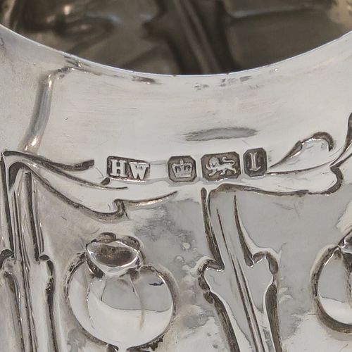 A very pretty Arts and Crafts Antique Edwardian Sterling Silver cream or milk jug having a round bellied body with hand-chased poppy seed head and leaf floral decoration, a cast scroll side-handle, and sitting on three cast trefoil feet. This beautiful Arts and Crafts style silver milk jug was made by Lee and Wigfull (Henry Wigfull) of Sheffield in 1903. The dimensions of this fine hand-made antique silver cream jug are height 9 cms (3.5 inches), length 9 cms (3.5 inches), and it weighs approx. 114g (3.7 troy ounces).