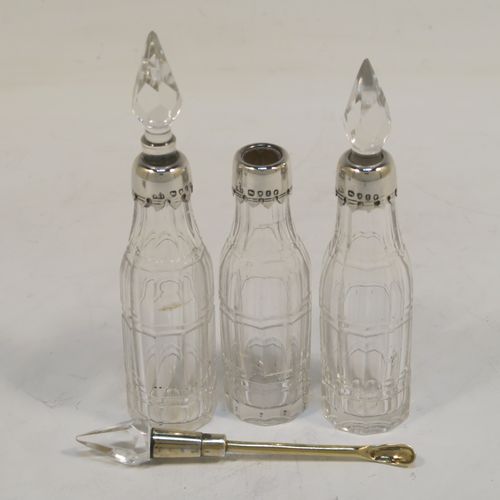A small but very pretty Antique Victorian Sterling Silver and crystal bottle cruet set, having a plain frame with applied reeded borders, a matching side-handle with thumb-piece, three original crystal bottles with stoppers and silver collars, two for oil and vinegar and the third for mustard or chili sauce with its original gold-gilt spoon, all sitting on a base with three flange feet. This beautiful cruet set was made by Francis Boone Thomas of London in 1873. The dimensions of this fine hand-made antique silver cruet set are height 13.5 cms (5.3 inches), length 7.5 cms (3 inches), and width 6 cms (2.3 inches).