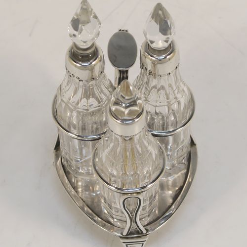 A small but very pretty Antique Victorian Sterling Silver and crystal bottle cruet set, having a plain frame with applied reeded borders, a matching side-handle with thumb-piece, three original crystal bottles with stoppers and silver collars, two for oil and vinegar and the third for mustard or chili sauce with its original gold-gilt spoon, all sitting on a base with three flange feet. This beautiful cruet set was made by Francis Boone Thomas of London in 1873. The dimensions of this fine hand-made antique silver cruet set are height 13.5 cms (5.3 inches), length 7.5 cms (3 inches), and width 6 cms (2.3 inches).