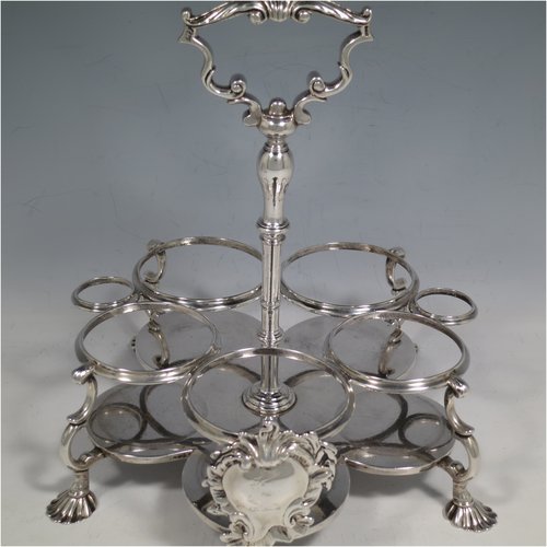 An Antique Georgian Sterling Silver and hand-cut crystal five-bottle Warwick style cruet set, having a stand with ring & scroll work holders, a cast loop handle with shell, a cast applied shell-style cartouche, and sitting on four cast shell feet. With two smaller baluster style pepper pots, a larger baluster sugar caster, and two hand-cut crystal oil & vinegar bottles with silver tops. Made by Samuel Woods of London in 1752-1754. The dimensions of this fine hand-made silver cruet set are width of stand 20 cms (8 inches), height of stand 23 cms (9 inches), and weight of silver approx. 1,500g (48 troy ounces). Please note that the silver tops on the crystal bottles are unmarked, and the stand is crested.