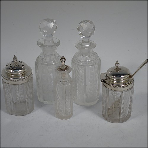 A very pretty Antique Victorian Sterling Silver table cruet set, consisting of two crystal bottles with original stoppers for oil and vinegar, a pepper shaker with crystal body and pierced silver lid, a salt/mustard pot with crystal body and silver hinged lid and condiment spoon, and a smaller bottle with silver serving spoon for a piquant sauce. All sitting in their original galleried frame with bead-edged borders, a cast laurel-leaf ring handle, and four cast claw and ball feet. Made by Martin Hall and Co., of Sheffield in 1868. The dimensions of this fine antique silver cruet set are height 15.5 cms (6 inches), and width 10 cms (4 inches).