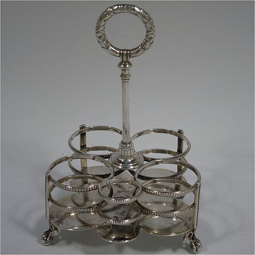 A very pretty Antique Victorian Sterling Silver table cruet set, consisting of two crystal bottles with original stoppers for oil and vinegar, a pepper shaker with crystal body and pierced silver lid, a salt/mustard pot with crystal body and silver hinged lid and condiment spoon, and a smaller bottle with silver serving spoon for a piquant sauce. All sitting in their original galleried frame with bead-edged borders, a cast laurel-leaf ring handle, and four cast claw and ball feet. Made by Martin Hall and Co., of Sheffield in 1868. The dimensions of this fine antique silver cruet set are height 15.5 cms (6 inches), and width 10 cms (4 inches).