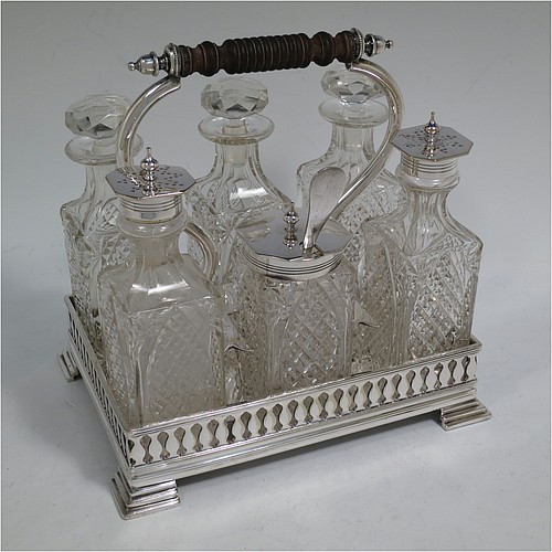 A very pretty Antique Victorian Silver Plated and hand-cut crystal cruet set, having six crystal bottles with original stoppers and silver mounts, sitting in a rectangular hand-pierced gallery frame with reeded borders, on four cast stepped feet. Made by Henry Hobson and Son, of Sheffield in ca. 1890. The dimensions of this fine hand-made antique silver-plated cruet set are height of frame 19 cms (7.5 inches), length 18.5 cms (7.3 inches), and width 14 cms (5.5 inches).   