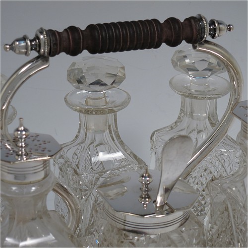 A very pretty Antique Victorian Silver Plated and hand-cut crystal cruet set, having six crystal bottles with original stoppers and silver mounts, sitting in a rectangular hand-pierced gallery frame with reeded borders, on four cast stepped feet. Made by Henry Hobson and Son, of Sheffield in ca. 1890. The dimensions of this fine hand-made antique silver-plated cruet set are height of frame 19 cms (7.5 inches), length 18.5 cms (7.3 inches), and width 14 cms (5.5 inches).