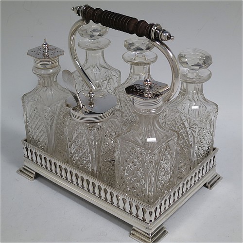 A very pretty Antique Victorian Silver Plated and hand-cut crystal cruet set, having six crystal bottles with original stoppers and silver mounts, sitting in a rectangular hand-pierced gallery frame with reeded borders, on four cast stepped feet. Made by Henry Hobson and Son, of Sheffield in ca. 1890. The dimensions of this fine hand-made antique silver-plated cruet set are height of frame 19 cms (7.5 inches), length 18.5 cms (7.3 inches), and width 14 cms (5.5 inches).
