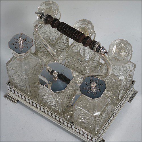 A very pretty Antique Victorian Silver Plated and hand-cut crystal cruet set, having six crystal bottles with original stoppers and silver mounts, sitting in a rectangular hand-pierced gallery frame with reeded borders, on four cast stepped feet. Made by Henry Hobson and Son, of Sheffield in ca. 1890. The dimensions of this fine hand-made antique silver-plated cruet set are height of frame 19 cms (7.5 inches), length 18.5 cms (7.3 inches), and width 14 cms (5.5 inches).
