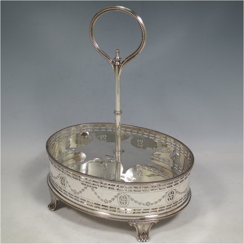 An Antique Victorian Sterling Silver large table cruet set, having a Neoclassical style oval stand with applied bead borders and hand-pierced and engraved decoration, with ring handle and a frame for seven hand-cut crystal cruet bottles with original stoppers and silver mounts, all sitting on a base with four flange feet. Made by James Dixon & Sons of Sheffield in 1872. The dimensions of this fine antique silver cruet set are height 26 cms (10.25 inches), length 20 cms (8 inches), width 16 cms (6.25 inches),and with a total weight of approx. 900g (29 troy ounces).
