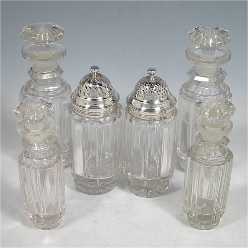 An Antique Georgian Sterling Silver large table cruet set, having a Regency style rectangular stand with an applied gadroon border, with ring handle and a frame for six hand-cut crystal cruet bottles with original stoppers and silver mounts, all sitting on a base with four cast lions paw feet. Made by William Bateman I of London in 1825. The dimensions of this fine antique silver cruet set are height 20 cms (8 inches), length 15 cms (6 inches), and width 13 cms (5 inches). Please note that the base has a wooden insert underneath.