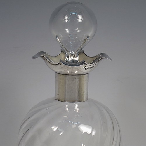 A very pretty Antique Victorian Sterling Silver and cut-crystal glug-glug decanter, having swirl-flute shoulders and clear bottom body, with four pinched and fluted central waists between, a plain round neck mount with four pouring spouts, and a hand-cut spherical crystal stopper. Made by Henry Miller of Birmingham in 1898. The dimensions of this fine hand-made antique silver and crystal glug glug decanter are height 28 cms (11 inches), and width at base 11.5 cms (4.5 inches).   