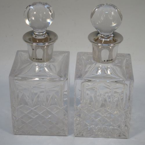 A very handsome pair of small Sterling Silver and hand-cut crystal decanters sitting in a galleried wood base, having square cross-section bodies with silver collars and original stoppers, all sitting in a silver galleried wooden base with green felt interiors. Made by Charles S. Green and Co. Ltd., of Birmingham in 1986. The dimensions of this fine pair of silver and crystal decanters (including base) are height 17 cms (6.75 inches), length 19 cms (7.5 inches), and width 10 cms (4 inches).