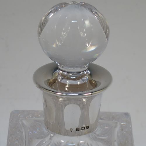 A very handsome pair of small Sterling Silver and hand-cut crystal decanters sitting in a galleried wood base, having square cross-section bodies with silver collars and original stoppers, all sitting in a silver galleried wooden base with green felt interiors. Made by Charles S. Green and Co. Ltd., of Birmingham in 1986. The dimensions of this fine pair of silver and crystal decanters (including base) are height 17 cms (6.75 inches), length 19 cms (7.5 inches), and width 10 cms (4 inches).