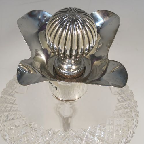 A large and very pretty Antique Victorian Sterling Silver and hand-cut crystal glug-glug decanter, having a hobnail pattern body, with four pinched and fluted central waists between, a plain round neck mount with four spouts, and a silver fluted and cork stopper. This beautiful antique silver and crystal decanter was made by Thomas Russell of Sheffield in 1894. The dimensions of this fine hand-made antique silver and crystal glug glug decanter are height 30 cms (11.75 inches), and width at base 12.5 cms (5 inches). Please note that this item is monogrammed opposite the hallmarks on the silver neck.